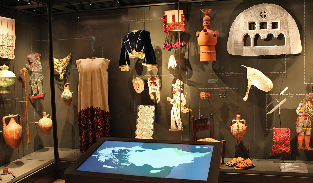 Large glass museum display case with utilitarian and decorative objects from Hellenism.