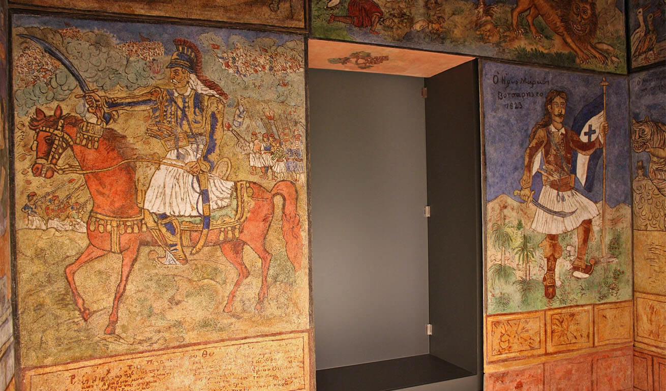 Colored murals in a folk style depicting heroes of the Greek Revolution.