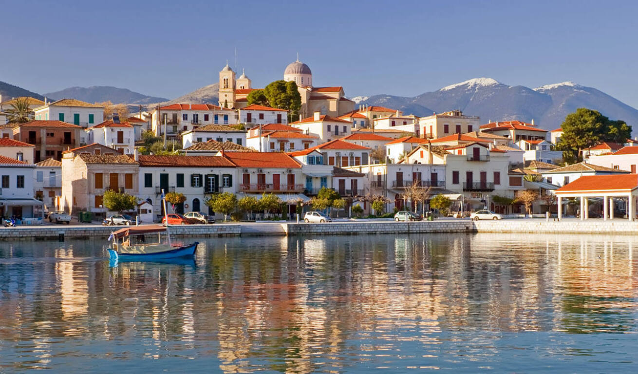 Άποψη του λιμανιού του χωριού, με μία ψαρόβαρκα στο κέντρο και πολλά παραδοσιακά σπίτια τριγύρω, και μία εκκλησία στην κορυφή