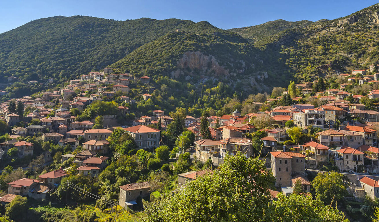 View of the traditional village, built on the foothills of the mountain, with many trees all around