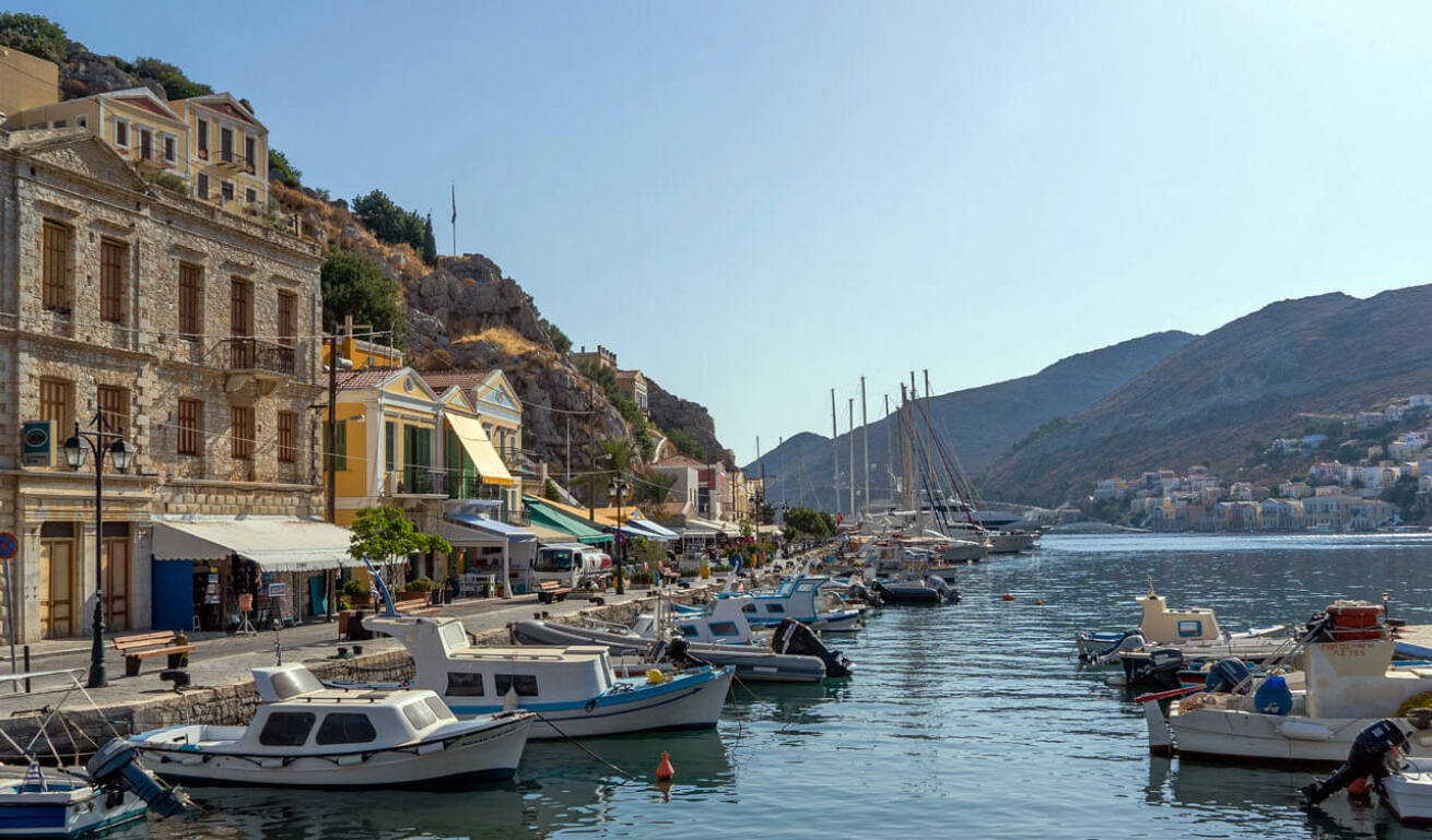 View of the port of the island with fishing boats and vessels and with traditional buildings and shops