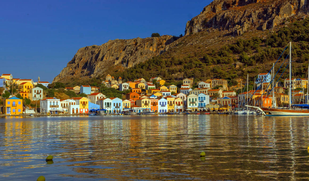View of the port of the island, with the colorful traditional houses and the boats in the background
