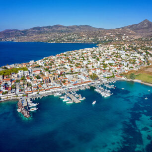 Γραφικό παραθαλάσσιο ηλιόλουστο χωριό με κεραμοσκεπές πάνω σε χερσόνησο.