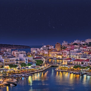 Panoramic view of the town of Agios Nikolaos, with the traditional houses and the illuminated port at night