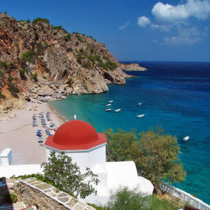 Kyra Panagia beach with people hanging around and a view of the church