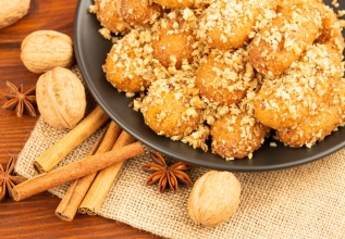 Greek biscuits known as melomakarona, dunked in honey syrup and sprinkled with crushed walnuts sprinkled and cinnamon spice