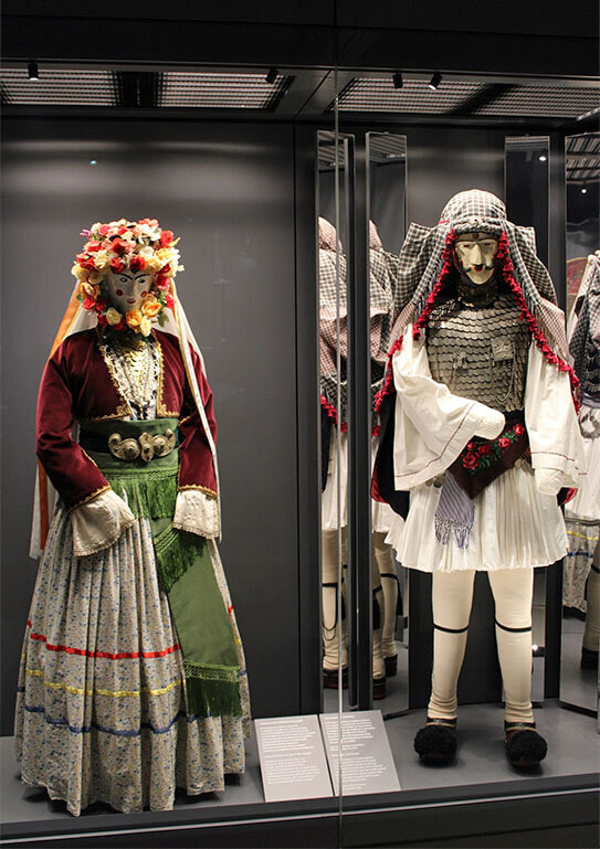 Large glass museum display case with traditional costumes.