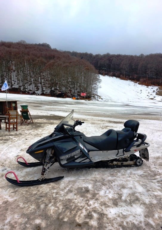 Snowbmobile surrounded by snow and mountains