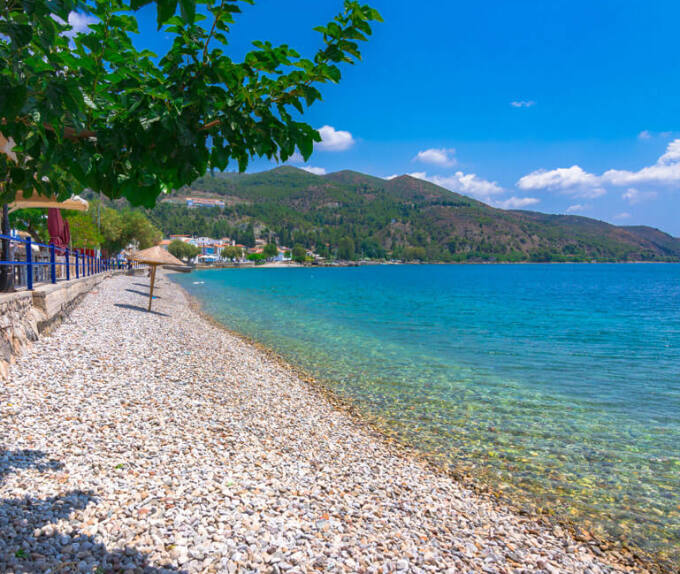 Μικρή παραθαλάσσια πόλη με παραλία με βότσαλα και γαλαζοπράσινα νερά