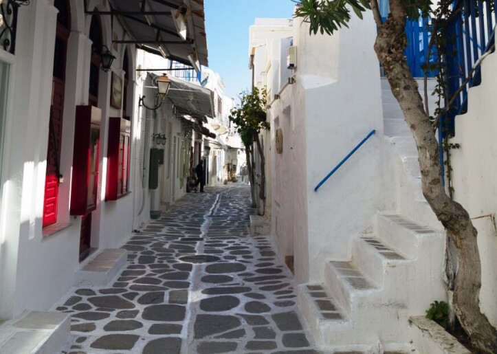Narrow alley, white-washed houses with red and blue shutters, handrails.
