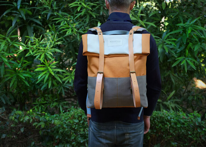 Άτομο που φορά ένα σακίδιο, που στέκεται μπροστά από το καταπράσινο φύλλωμα.