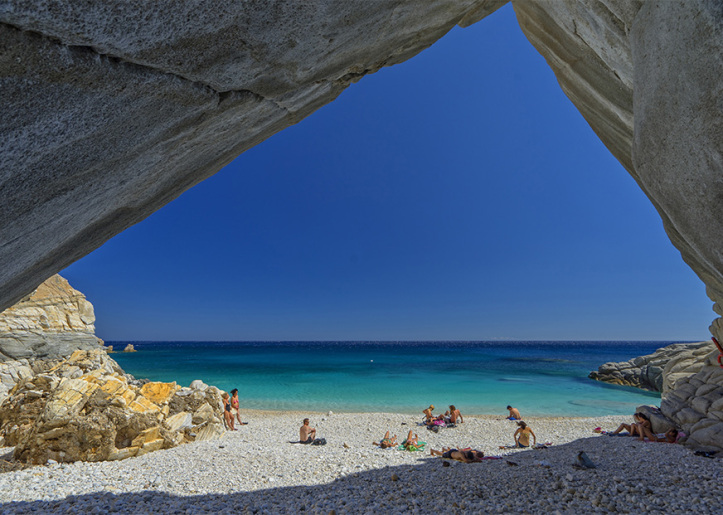 Beach in ikaria island with people sunbathing