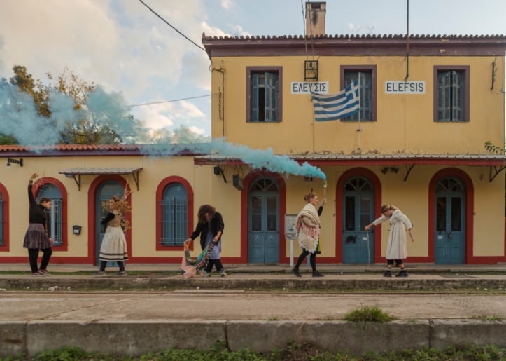 παλιό κτίριο σιδηροδρομικού σταθμού με καλλιτέχνες που στέκονται στην πλατφόρμα