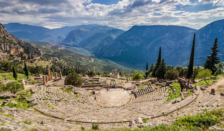 Πανοραμική άποψη του αρχαίου θεάτρου των Δελφών που περιβάλλεται από πολλά δέντρα