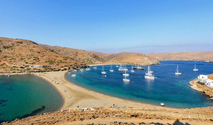 Thin strip of land that forms 2 beaches. Many sailing boats on one. Gentle hills with few buildings.