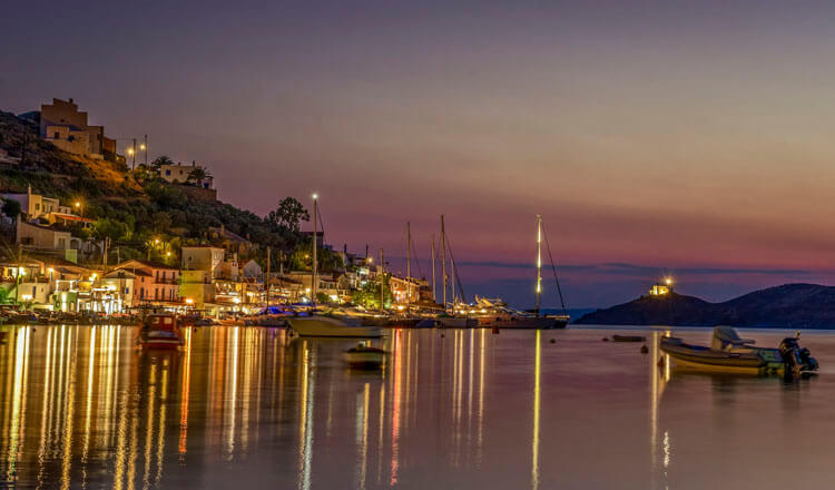 Μικρό γραφικό λιμάνι με μικρά σκάφη την νύχτα με φώτα.