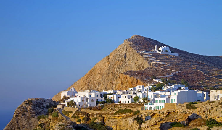A small picturesque settlement with white houses and a church perched on a rocky hill, to which a white path leads. 