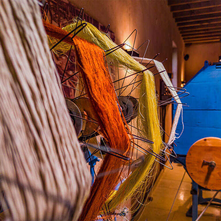 Colourful yarn spools on a spinning machine in a textile museum.