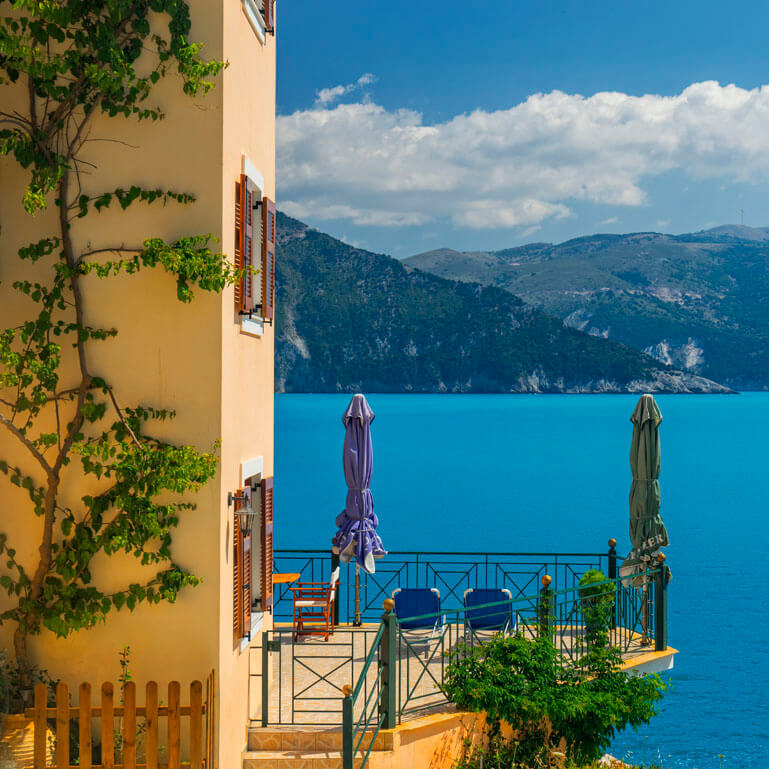 Μπαλκόνι με θέα τη γαλάζια θάλασσα στο μικρό παραθαλάσσιο χωριό Άσσος