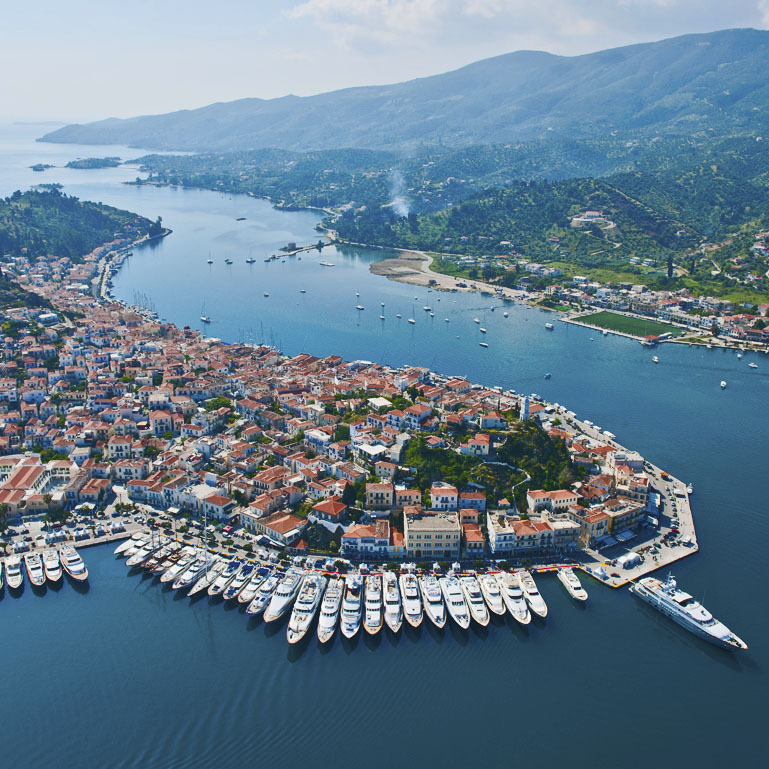 Picturesque small town with tiled rooftops next to a port with boats