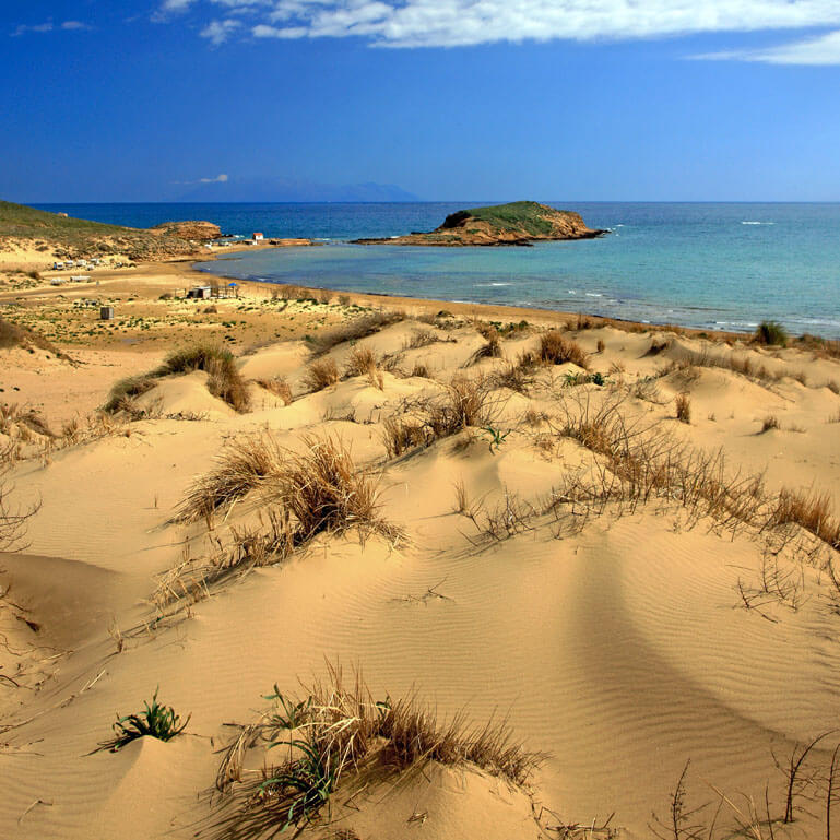 Sandy beach with a view to the greenish blue sea