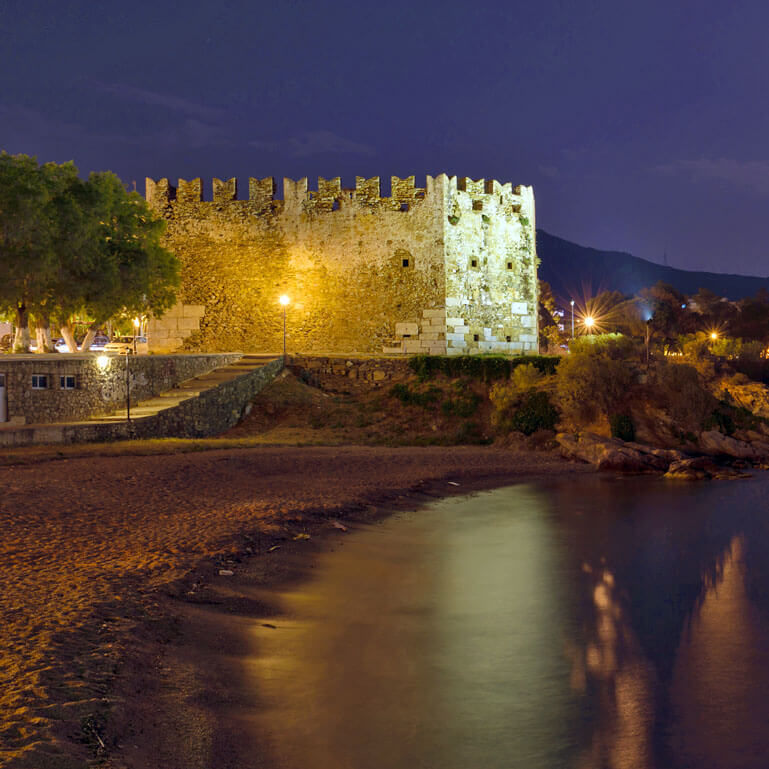 View of the medieval Fort Bourtzi at night, overlooking the sea
