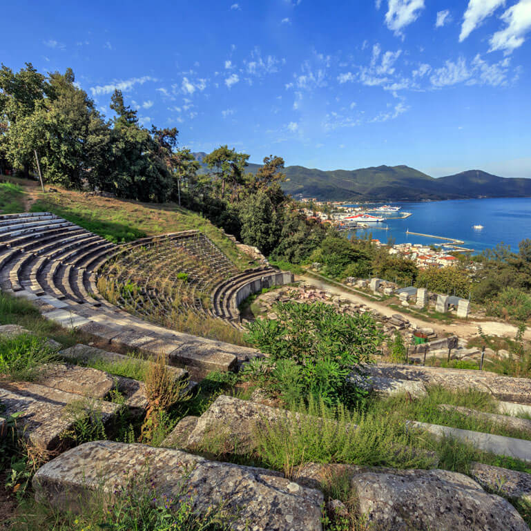 Ancient theatre with a village and the sea in the background