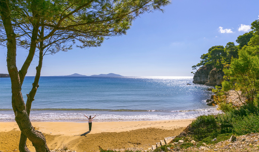 sandy beach. there is a woman with her hands in the air