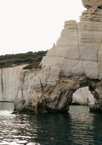 View of the iconic Kleftiko rock formations with natural arches over the clear blue waters, located on Milos Island, Greece.