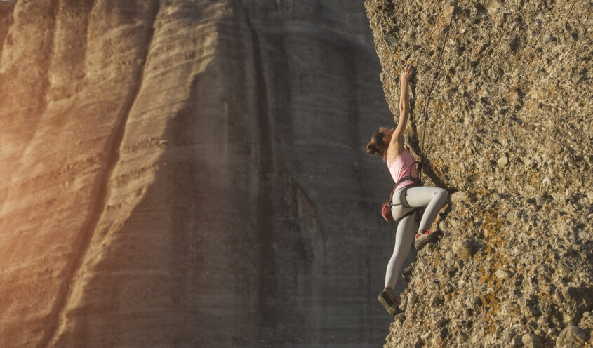 a woman climbing a rock